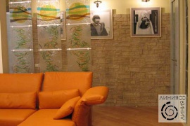фото дизайна интерьера  гостиная с витражами и каменной стеной